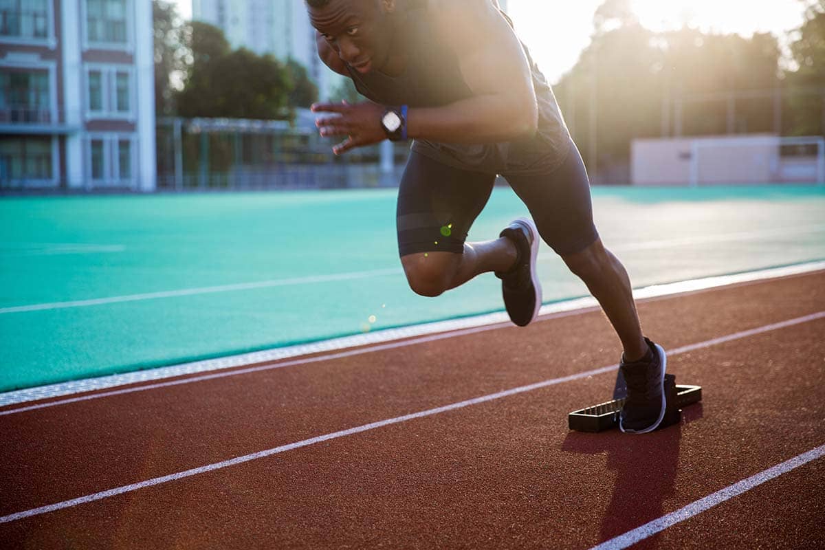 athlete running on track during athletic therapy